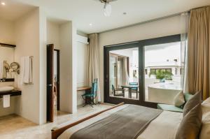 a bedroom with a bed and a bathroom with a tub at Mak Nuk Village - Clothing Optional in Tulum +67 photos