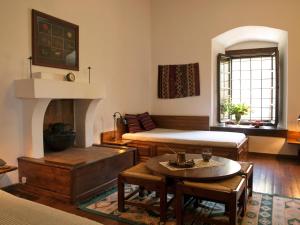 a living room with two beds and a fireplace at Mansion Karagiannopoulou in Vyzitsa
