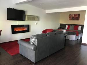 a living room with a couch and a bed and a fireplace at CCBC Resort Hotel - A Gay Men's Resort in Cathedral City