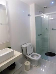 ein Badezimmer mit Toilette und Glasdusche in der Unterkunft Temporada Praia de Palmas SC in Governador Celso Ramos + 11 Fotos