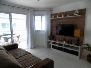 a living room with a couch and a flat screen tv at Temporada Praia de Palmas SC in Governador Celso Ramos