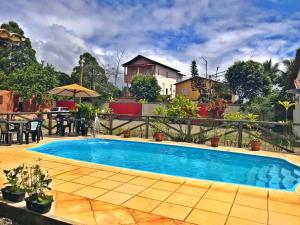 a swimming pool in front of a house at Pousada Vista da Pedra in Itamaraju