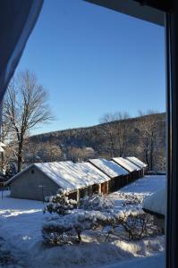 een met sneeuw bedekt gebouw met een met sneeuw bedekt dak bij Apartament Izerski Klimat in Świeradów-Zdrój