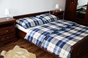 een slaapkamer met een bed met een blauwe en witte plaid bij Apartament Izerski Klimat in Świeradów-Zdrój