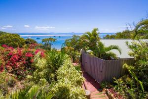 a view of the ocean from a garden with flowers at 1770 Beach Shacks in Seventeen Seventy