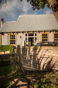 uma casa com um banco de madeira em frente em Noah's Boutique Accommodation Moeraki em Moeraki