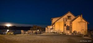 un edificio antiguo con mesas y sillas por la noche en Noah's Boutique Accommodation Moeraki, en Moeraki