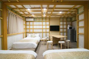 a room with three beds and a table and a desk at ETAVIA Yufuinekimae in Yufuin +50 photos