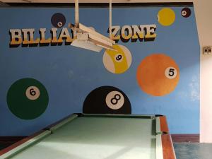 uma mesa de bilhar em frente a uma parede com planetas em Riverview Resort and Conference Center em Calamba