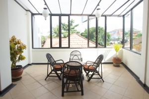 a porch with a table and chairs and windows at Maxi Hotel Kedonganan in Jimbaran