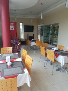 a dining room with tables and chairs and a tv at Hotel Sierra Inn in Xicotepec de Juárez