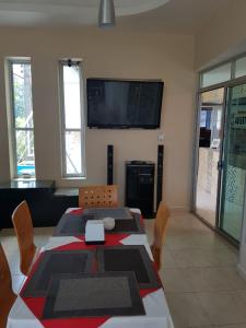 a dining room with a table and a television on the wall at Hotel Sierra Inn in Xicotepec de Juárez