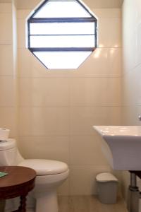 La salle de bains est pourvue d'un lavabo, de toilettes et d'une fenêtre. dans l'établissement Hotel Boutique Molino Viejo, à San Carlos