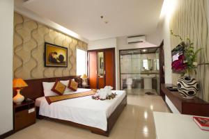 a bedroom with a large bed and a bathroom at Star Hotel and Spa Danang in Danang