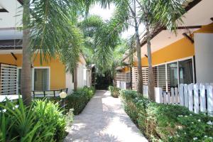 a walkway in front of a building with palm trees at KK Lipe Resort in Ko Lipe