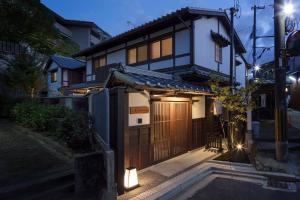 a house with a gate and lights on a street at THE MACHIYA VILLA Sanjo Shirakawa Koji in Kyoto