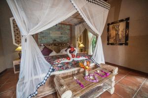 a bedroom with a canopy bed with a swan on it at Global Royal Pemuteran in Pemuteran