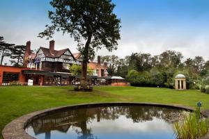 a large house with a pond in front of it at Royal Court Hotel & Spa Coventry in Coventry