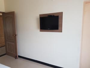 a room with a tv on a white wall at SK Residency in Coimbatore