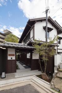 a house with a gate in front of it at THE MACHIYA VILLA Sanjo Shirakawa Koji in Kyoto