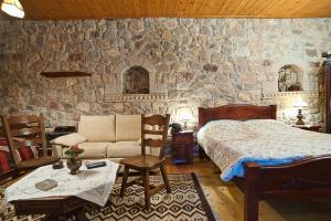 a bedroom with a bed and a stone wall at Alexandros Pension in Delphi