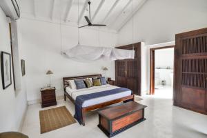 a bedroom with a king sized bed and a chandelier at Villa 32 Middle Street in Galle