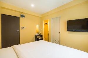 ein Schlafzimmer mit Bett und Flachbildfernseher in der Unterkunft The Corner Ratchada in Bangkok + 44 Fotos