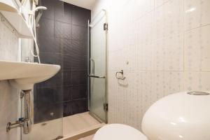 ein Badezimmer mit Toilette, Waschbecken und Dusche in der Unterkunft The Corner Ratchada in Bangkok