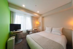 une chambre d'hôtel avec un lit et une télévision dans l'établissement Hotel Granvia Osaka-JR Hotel Group, à Osaka