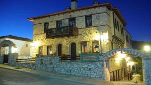 - un vieux bâtiment en pierre avec un balcon dans une rue dans l'établissement To Patriko, à Elatochori