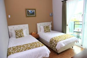 two beds in a room with a window at 500Km Home in Hualien City