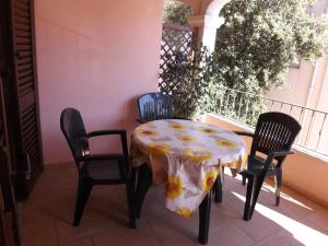 カーラゴノネにあるCorallo Aparmentのテーブルと椅子、テーブルとテーブルクロス付きのバルコニー