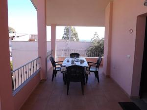 un patio con tavolo e sedie su un balcone di Corallo Aparment a Cala Gonone