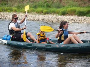 a man and two women and a child in a kayak on a river at Conjunto Hotelero La Pasera in Soto de Cangas