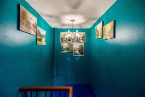 ein blaues Zimmer mit Bildern an der Wand in der Unterkunft The Corner Ratchada in Bangkok