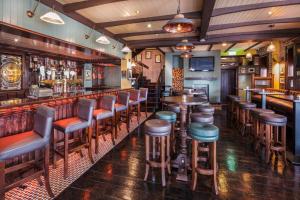 un bar con sgabelli in legno in una stanza di Downings Bay Hotel a Downings