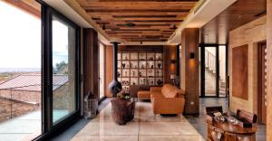 a living room with a couch and large windows at Ariana Sustainable Luxury Lodge - Special Category - Cappadocia in Uchisar