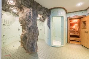 a bathroom with a fake rock on the wall at Almliesl HOLL-556 in Hollersbach im Pinzgau +26 photos