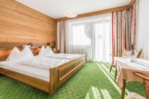 a bedroom with a large bed and a table at Almliesl HOLL-556 in Hollersbach im Pinzgau