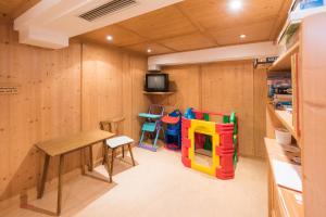 a room with a table and chairs and a tv at Almliesl HOLL-556 in Hollersbach im Pinzgau