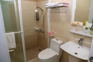 a bathroom with a shower and a toilet and a sink at 500Km Home in Hualien City