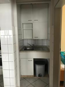 a kitchen with white cabinets and a sink and a trash can at Winterbergappartementen 27-10 in Winterberg +14 photos