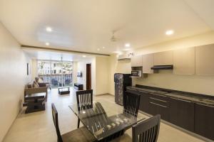 a kitchen and living room with a glass table and chairs at Eternal wave by HappyInch in Calangute