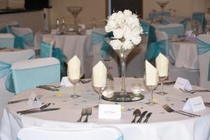 a table with white flowers in a vase on it at Warrens Village Motel and Self Catering in Clevedon