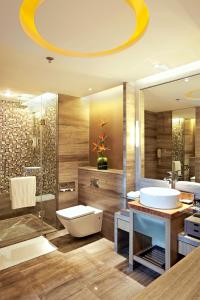a bathroom with a sink and a toilet and a shower at Pullman Xiamen Powerlong in Xiamen