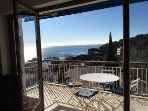 a balcony with a table and a view of the ocean at Appartement Cassis Plage in Cassis