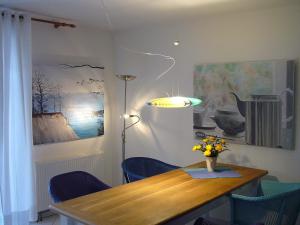 ein Esszimmer mit einem Holztisch und blauen Stühlen in der Unterkunft Ich kenne ein Haus am Meer in Putbus
