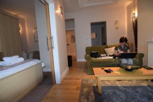 a woman sitting on a couch with a laptop in a hotel room at Easby Hall 22 in Scarborough