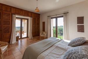 a bedroom with a large bed and a balcony at Mansion Ses Oliveres in S'Horta
