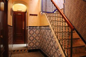 a staircase in a building with a brown door at Pensión Dulces Sueños in Seville